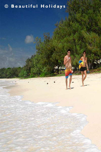 couple walking on white sandy beach
